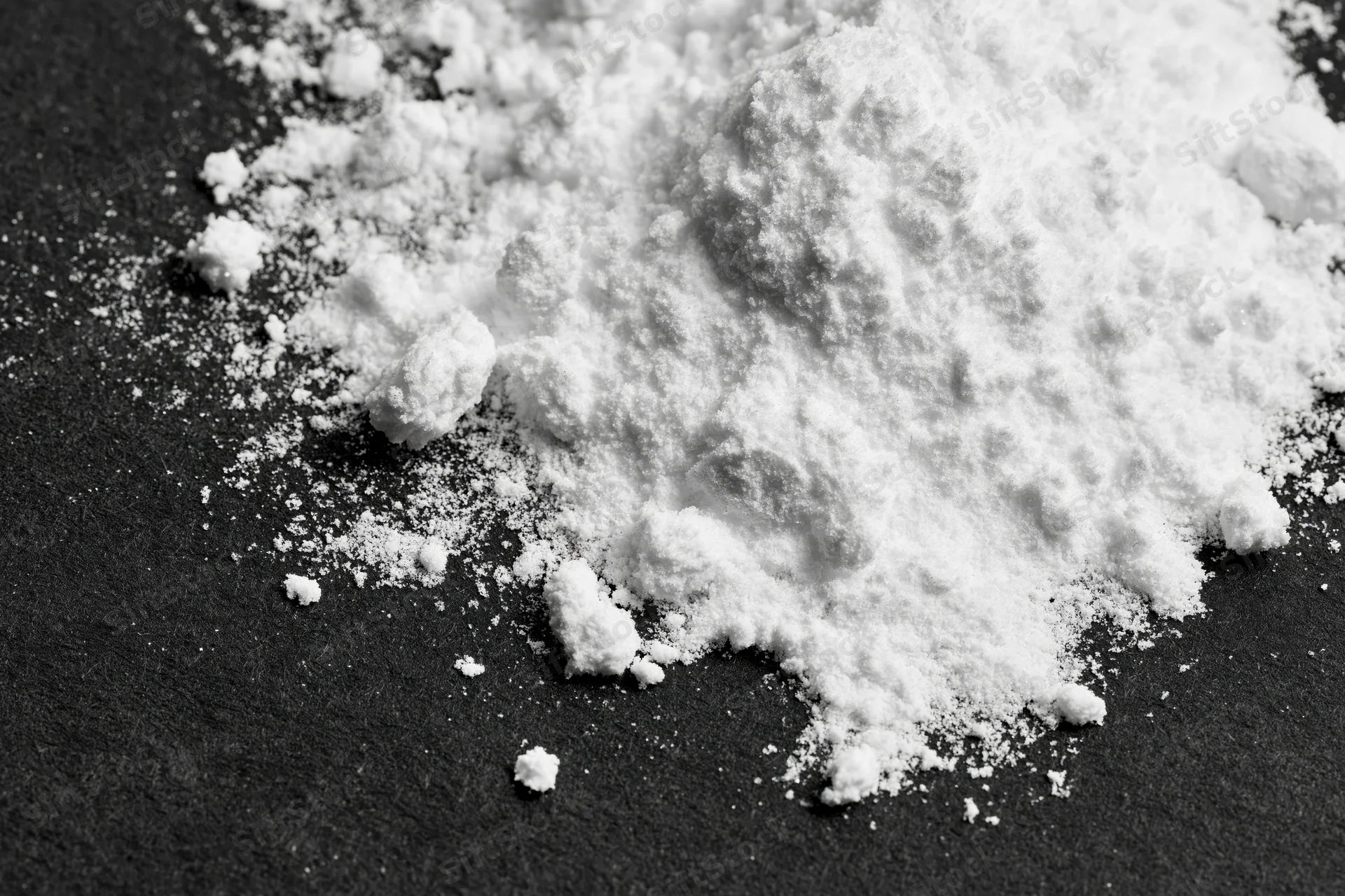 White powder scattered across a black surface