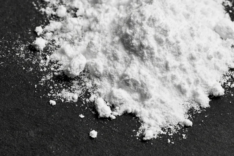 White powder scattered across a black surface