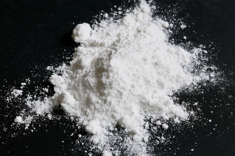 White powder scattered across a flat black surface