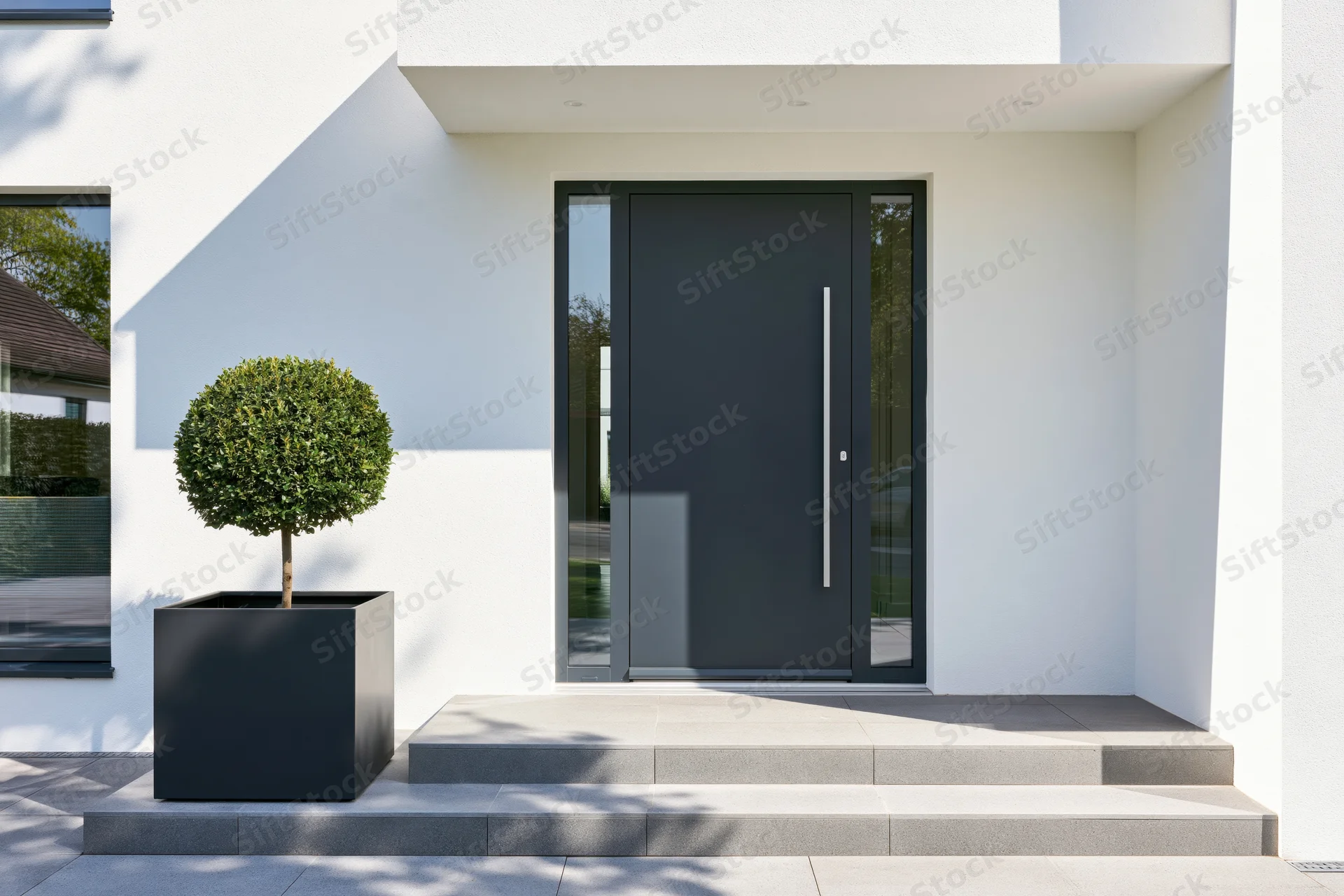 Modern residential entrance with charcoal pivot front door and minimalist landscaping