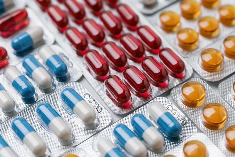 Multiple blister packs of pharmaceutical capsules and pills arranged in close-up view