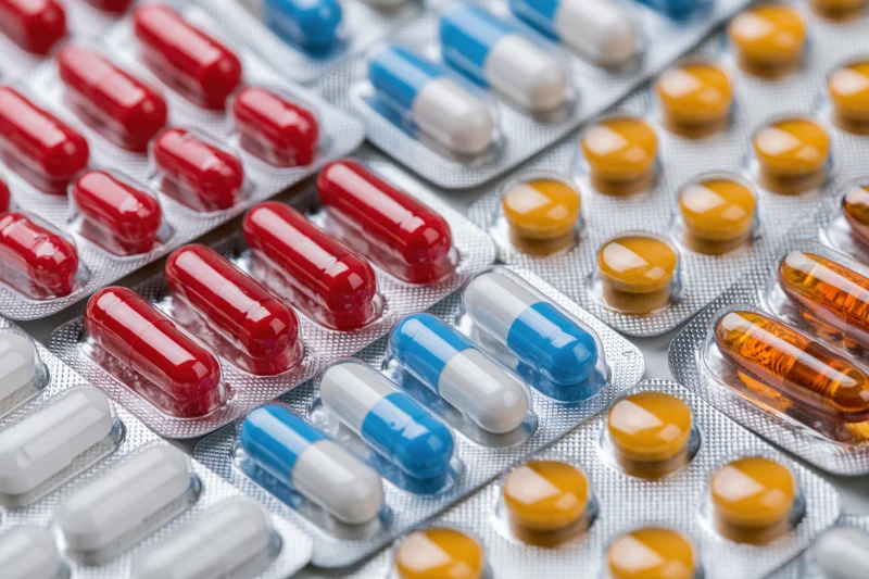 Multiple blister packs of pharmaceutical capsules and pills arranged in close-up view