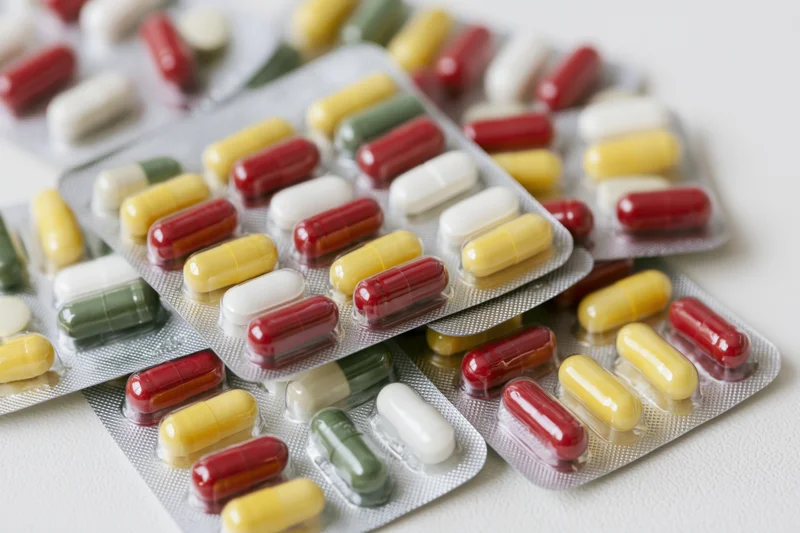 Multiple pharmaceutical blister packs scattered and overlapping on a white surface