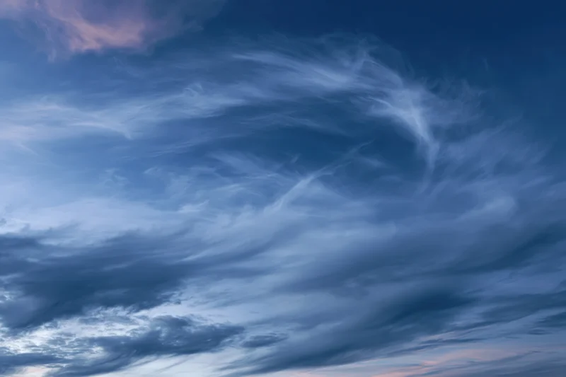 Twilight sky with wispy cirrus clouds layered across the horizon