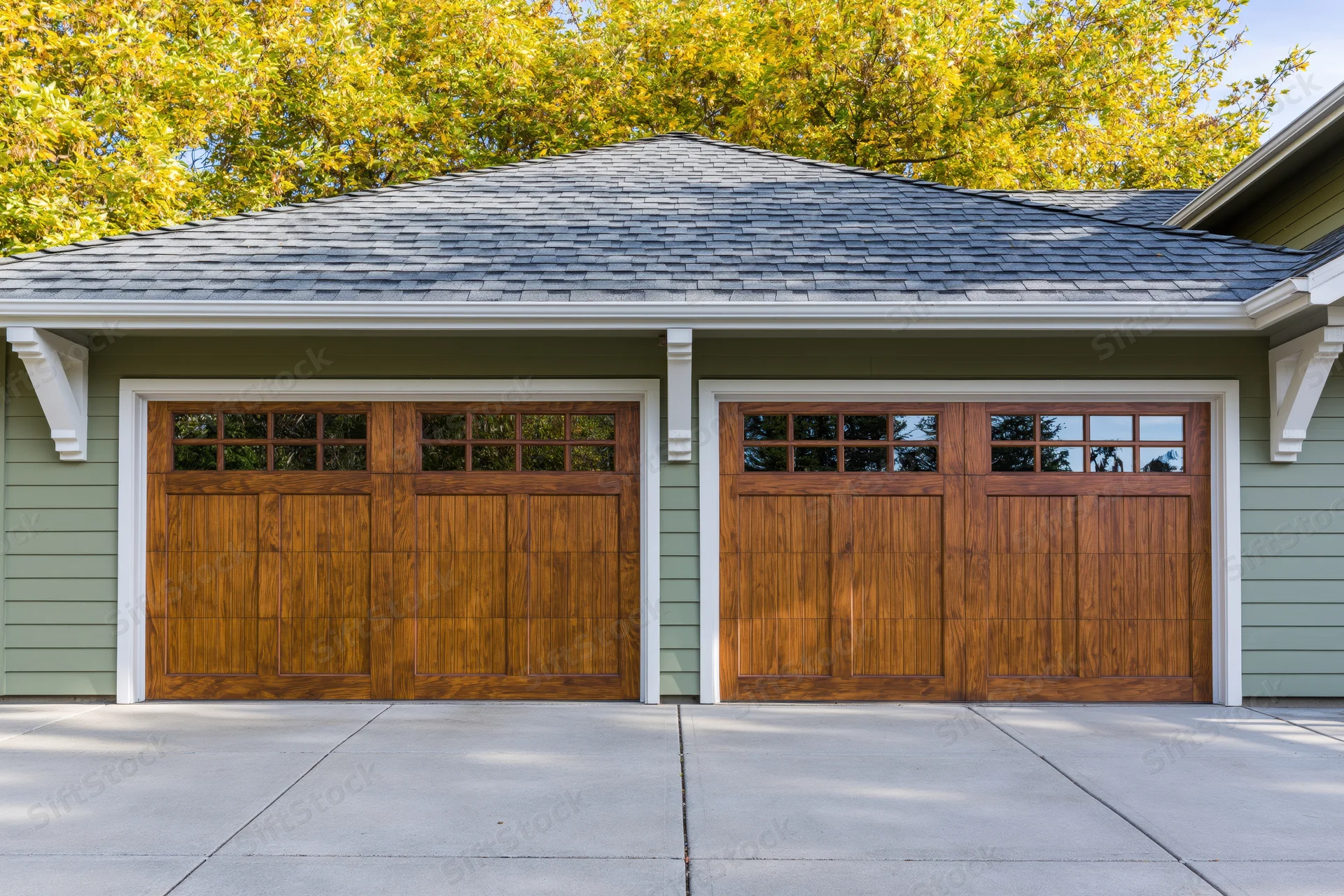 Two-car garage with wooden doors on a suburban craftsman home exterior