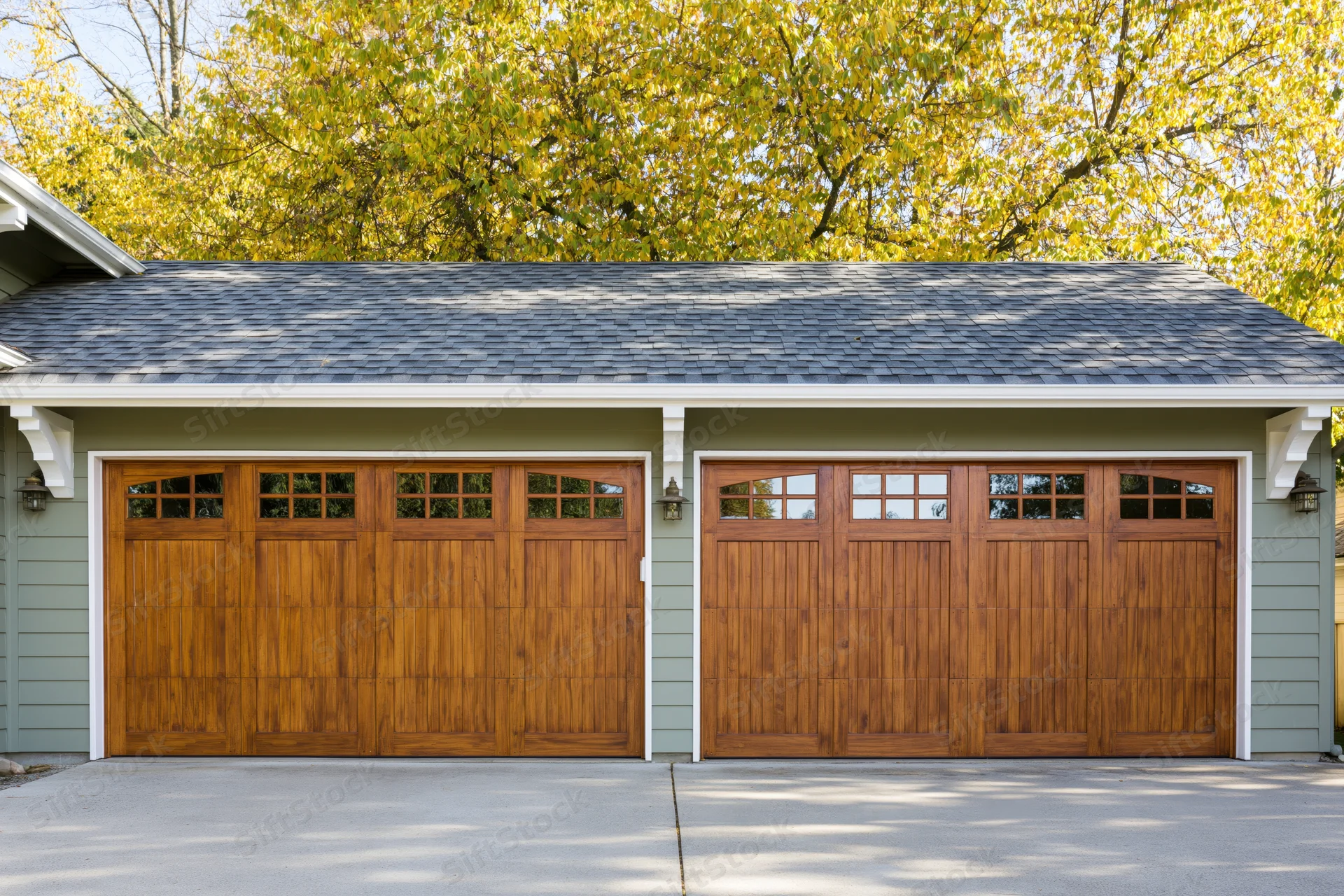 Two-car garage with wooden doors on a suburban craftsman home exterior