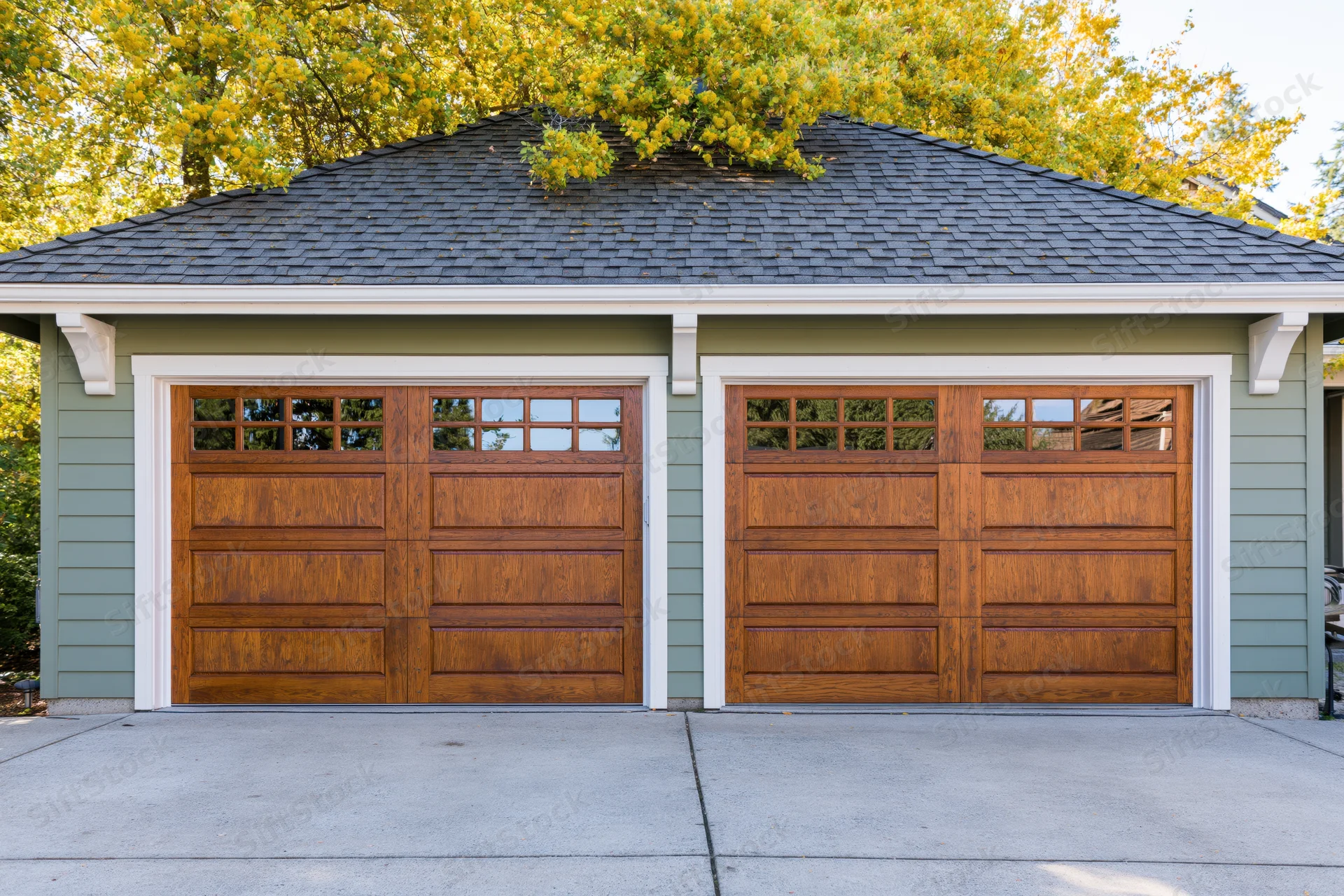 Two-car garage with wooden doors on a suburban craftsman home exterior