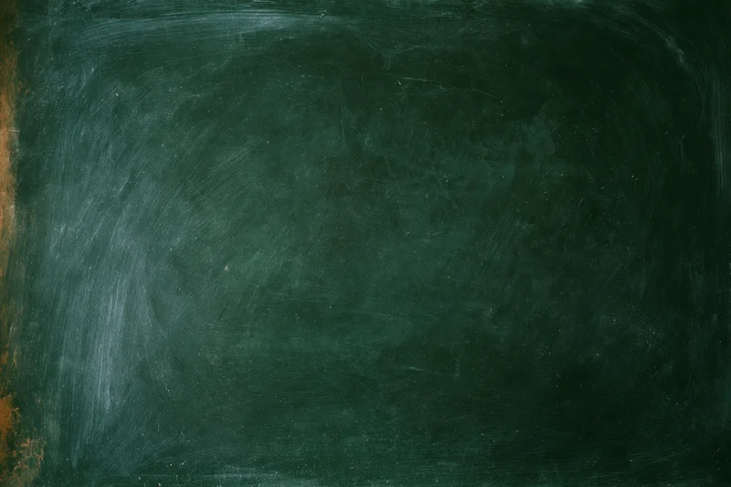 Worn dark green chalkboard surface filling the frame with smudged marks and dust residue