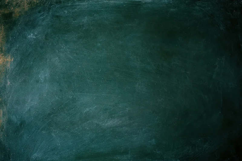 Worn dark green chalkboard surface filling the frame with smudged residue and scratches