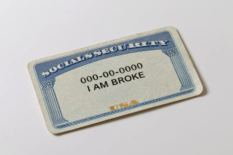 Us social security card with text i am broke lying flat on white surface