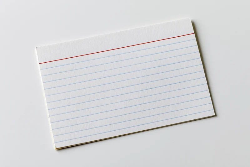 Blank ruled index card lying flat on white surface