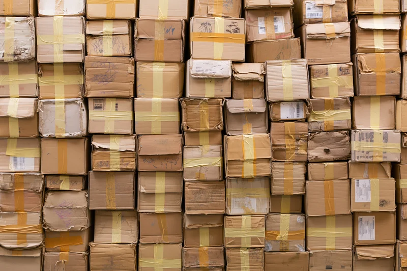 Dense wall of stacked used cardboard boxes filling the frame