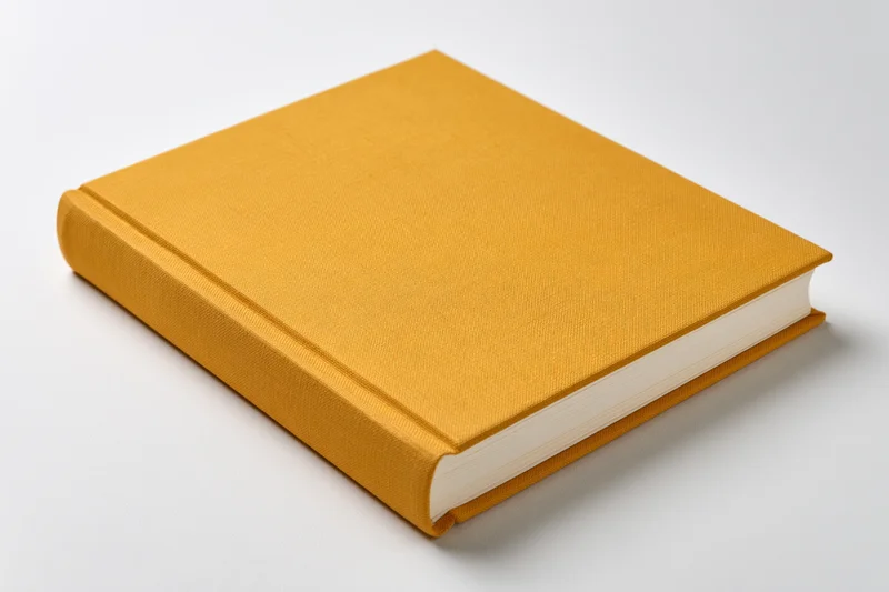 Mustard-yellow hardcover book with plain cloth cover on white background
