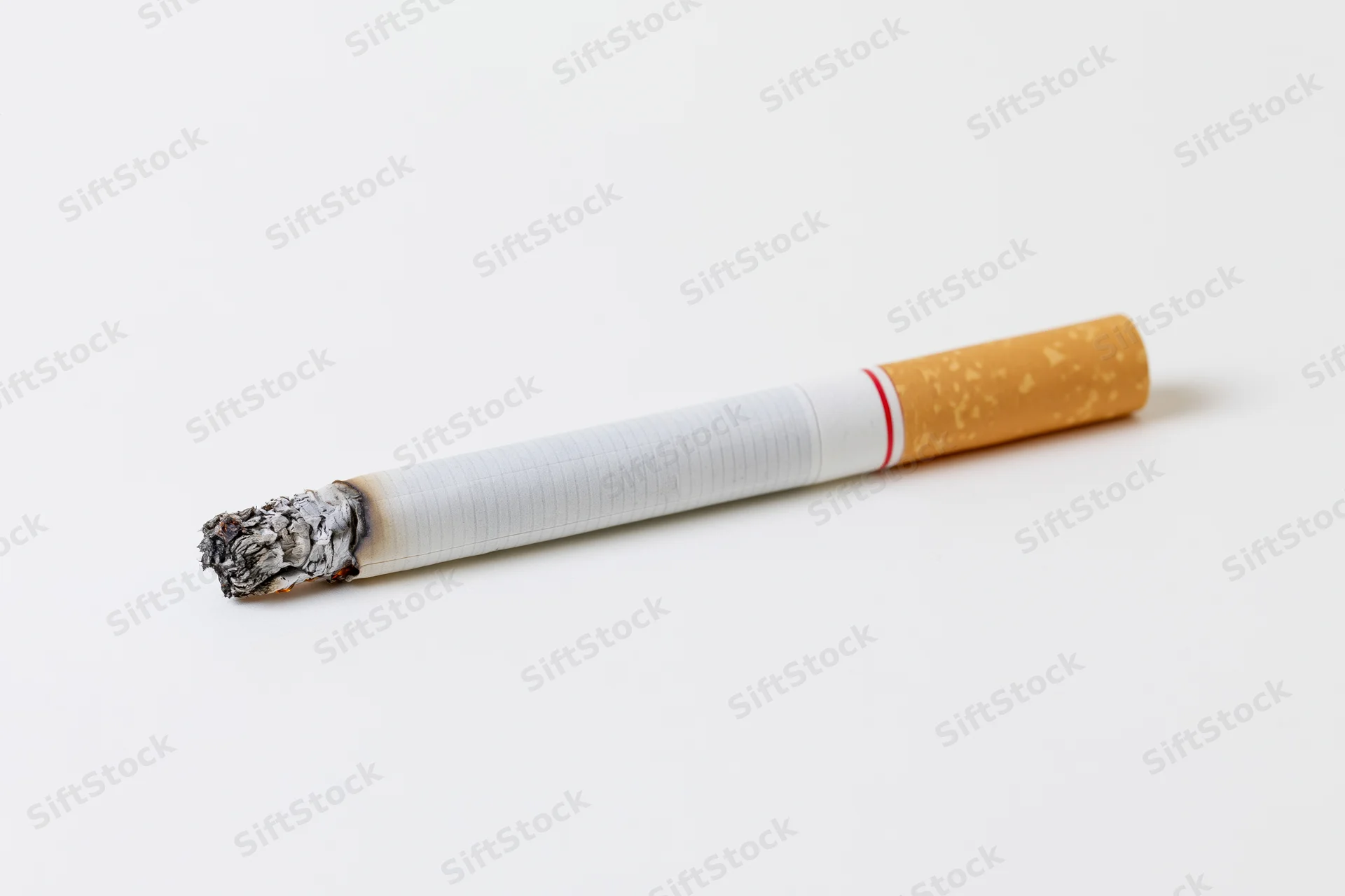 Lit cigarette with ash tip on white background