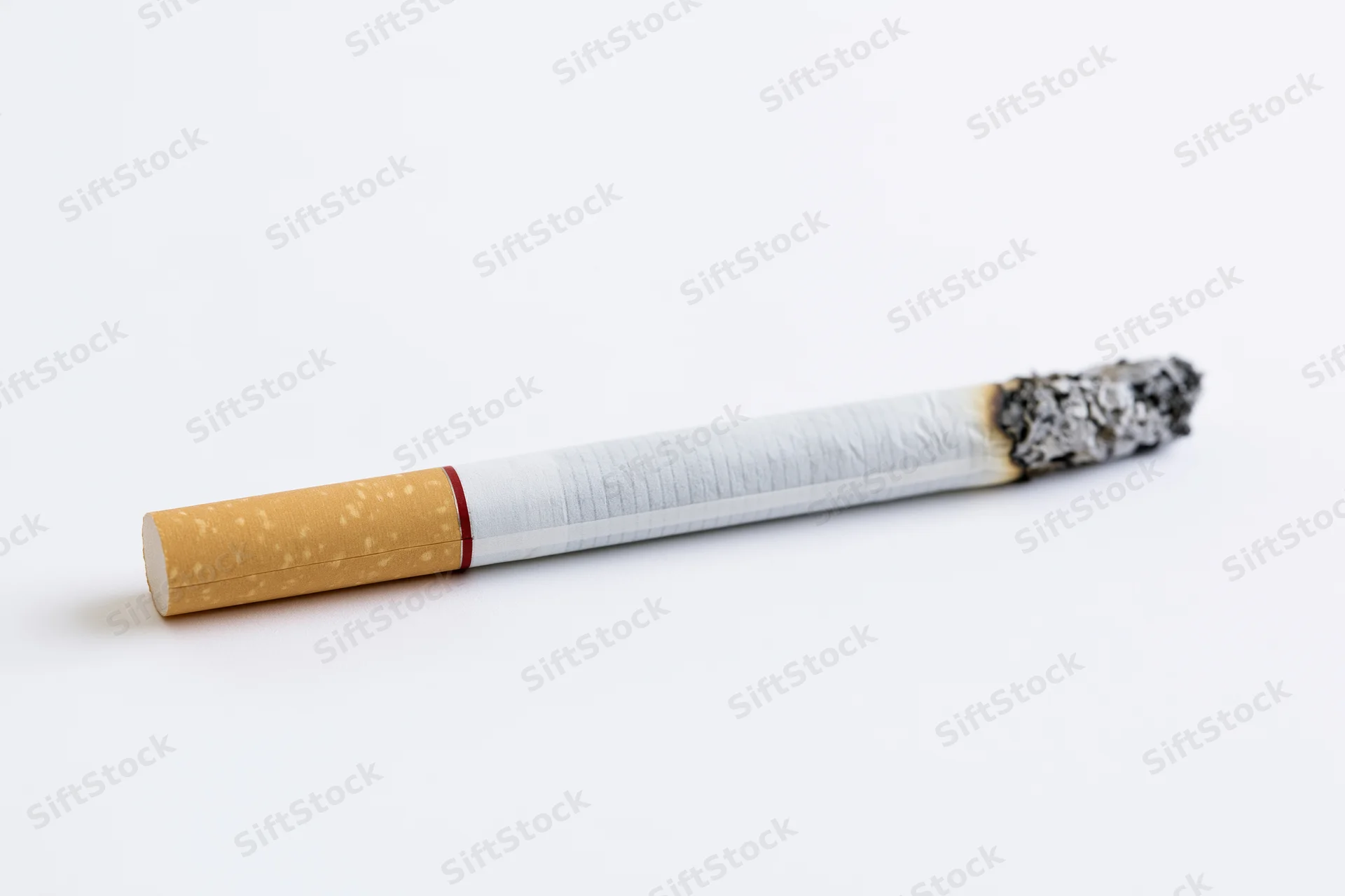 Lit cigarette with ash tip on white background