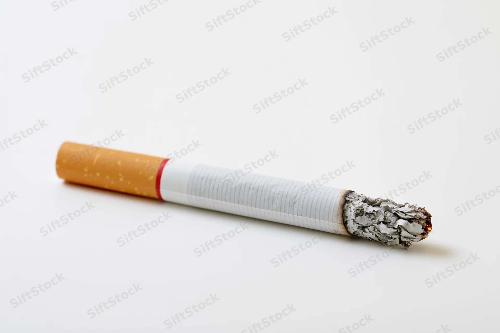 Lit cigarette with glowing ash tip on white background