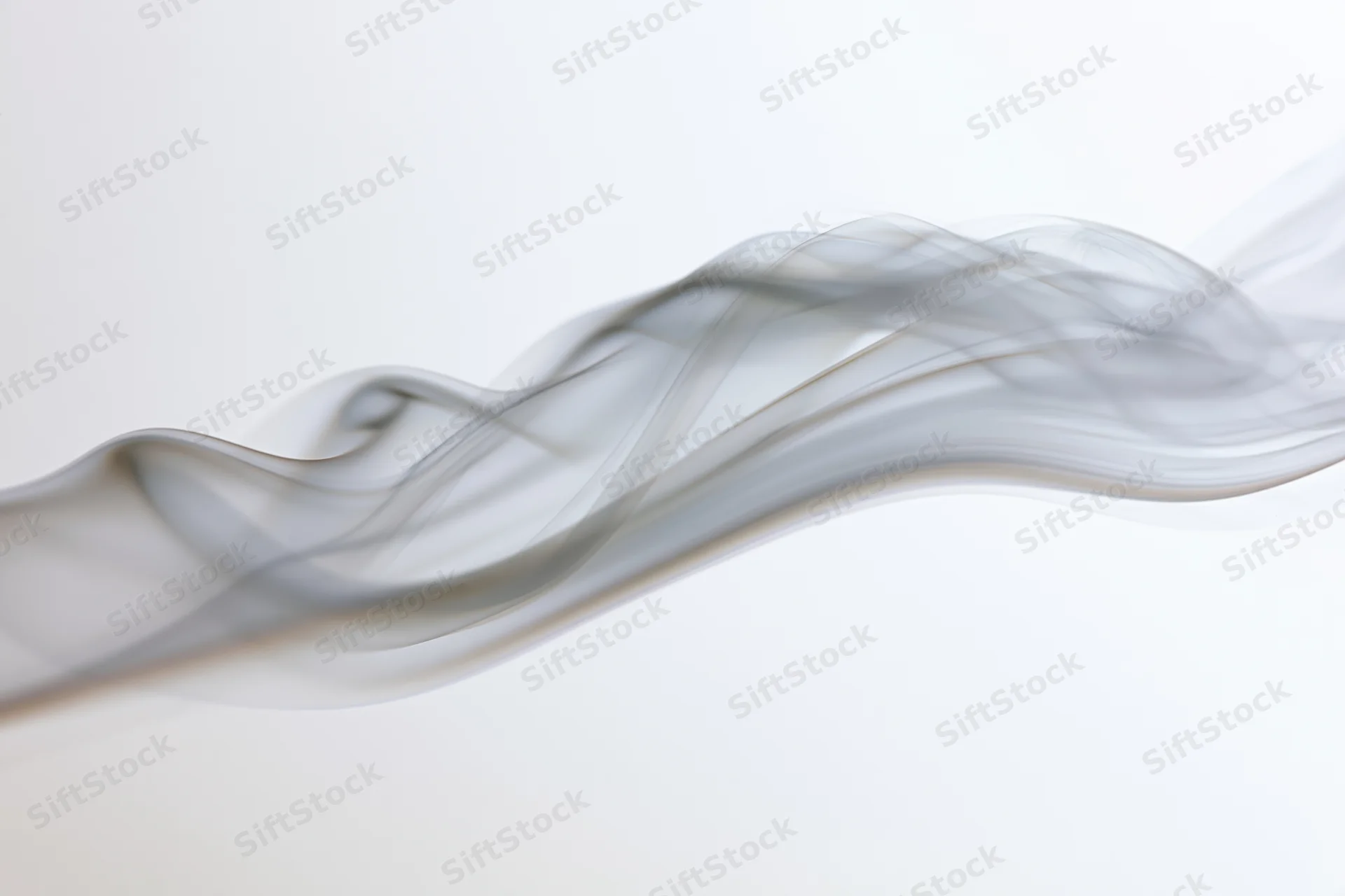 Thin wisp of white smoke curling upward against a plain white background