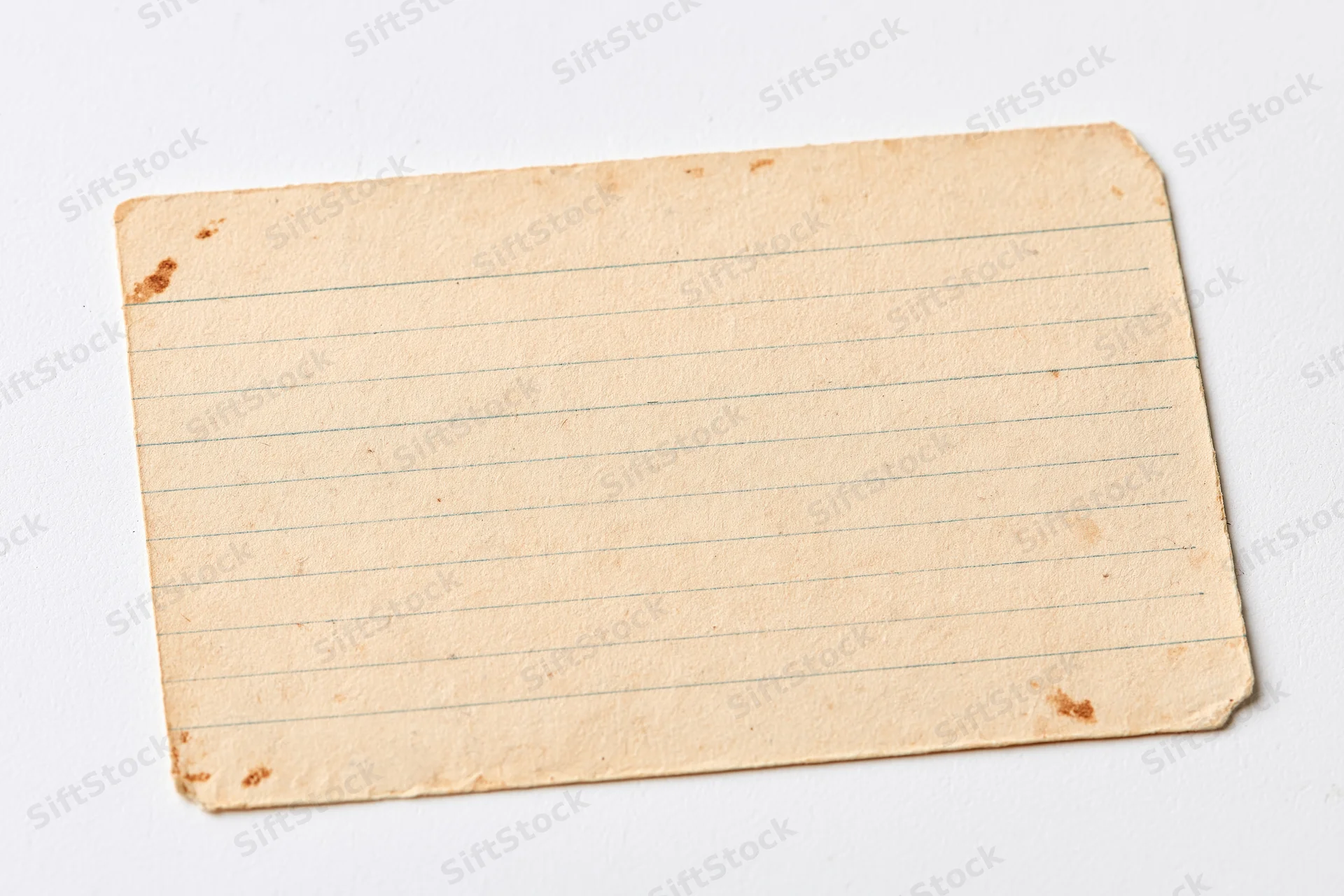 Aged blank lined index card lying flat on white background