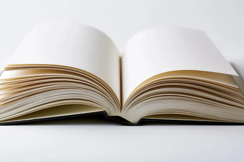 Open hardcover book with pages fanned outward symmetrically on white surface