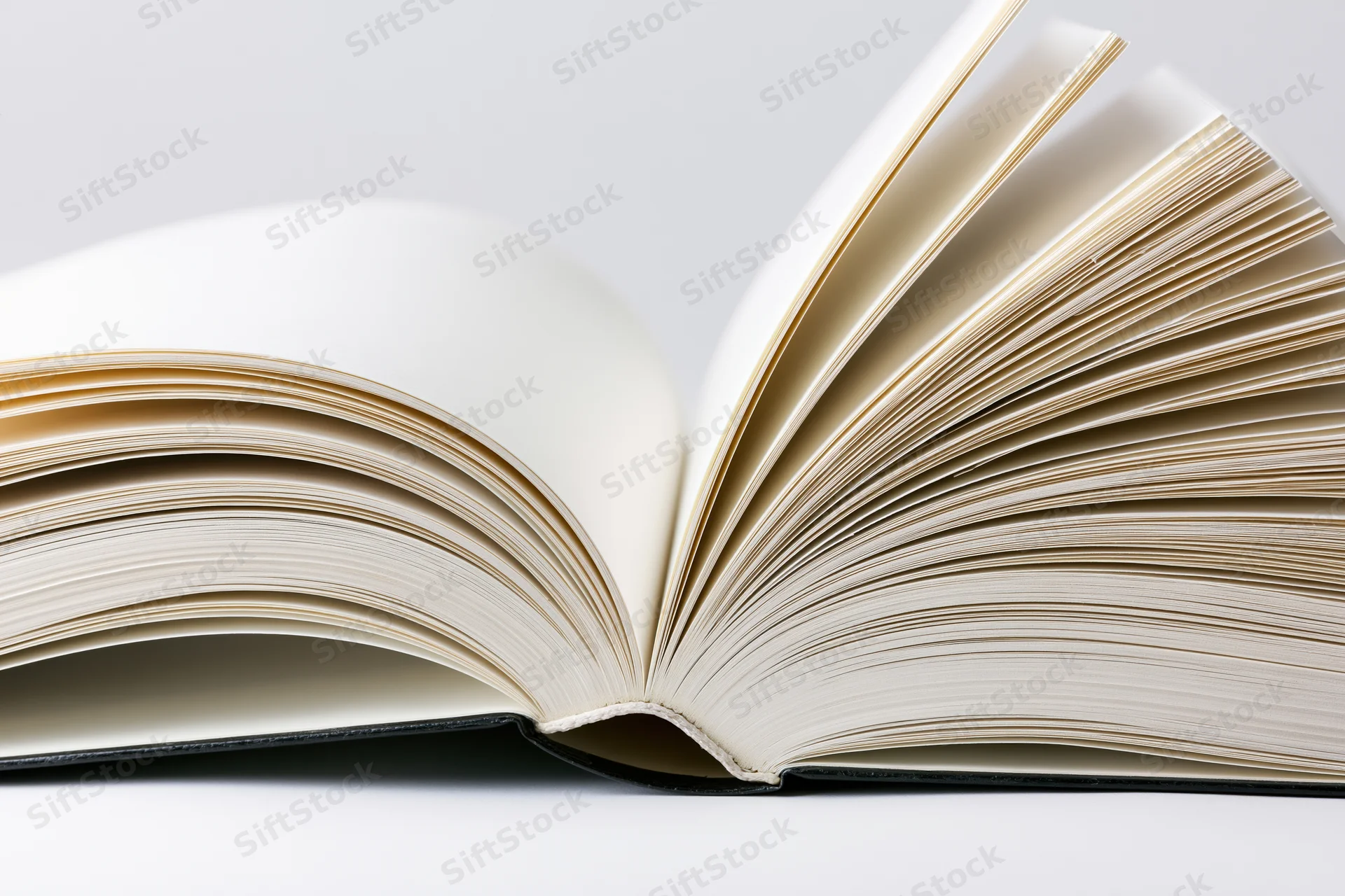 Open hardcover book with pages fanned outward symmetrically on white background