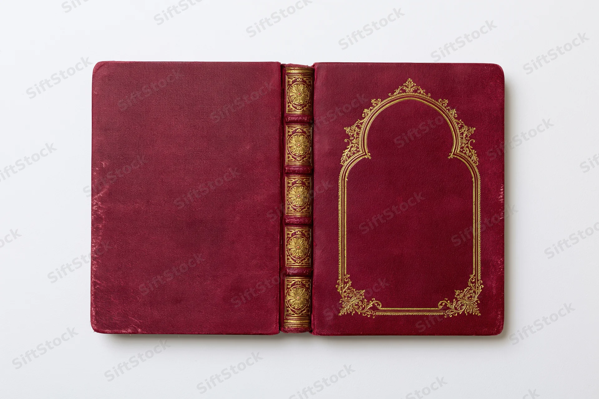 Antique hardcover book opened flat showing both covers and spine with gold embossed decoration on maroon velvet material