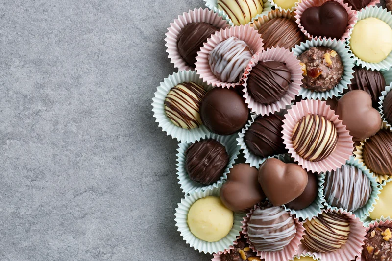 Assorted chocolate truffles and pralines in pastel paper cups