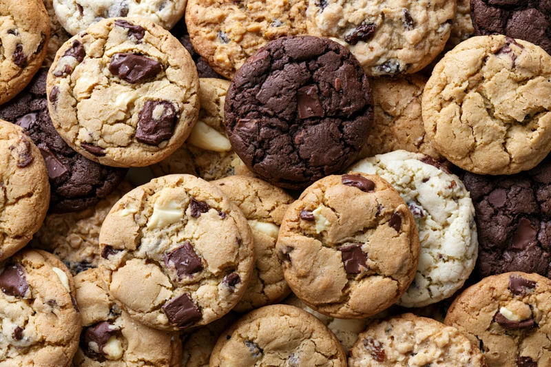 Assorted homemade cookies piled together filling the frame in a close-up top view