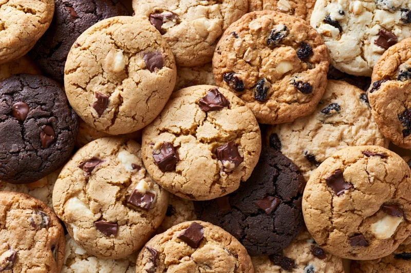 Assorted homemade cookies piled together filling the frame in a close-up top view