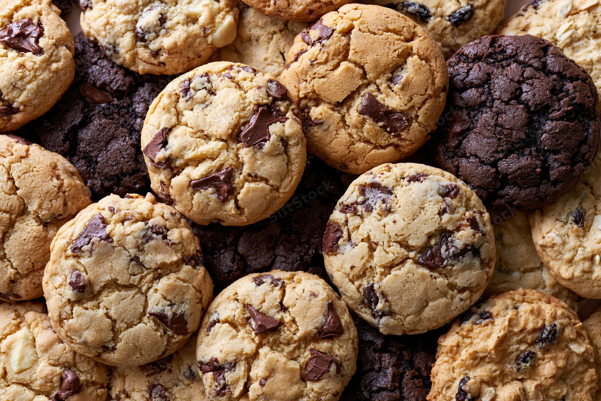 Assorted homemade cookies piled together filling the frame in a close-up top view