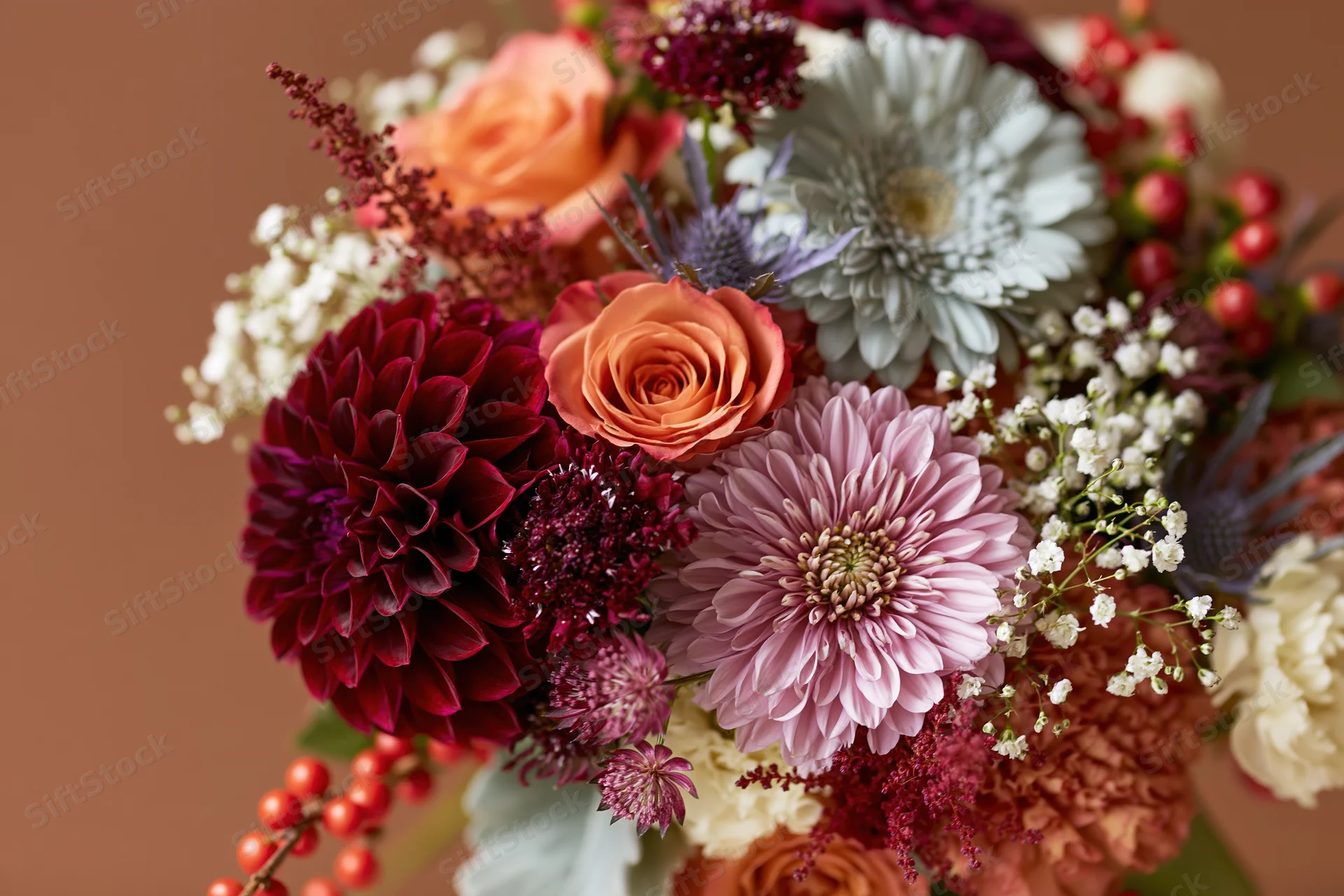 Autumn floral bouquet with dahlias, roses, and berries arranged for event decoration