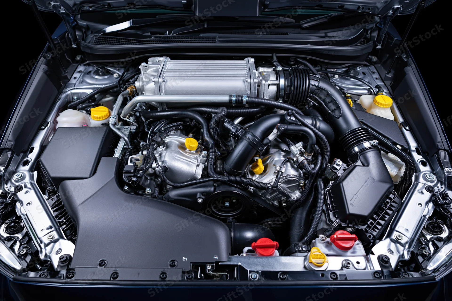 Open car hood revealing engine bay with intercooler and mechanical components