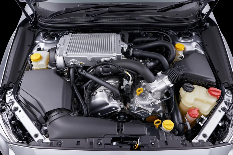 Car engine bay with hood open showing intercooler and fluid reservoirs