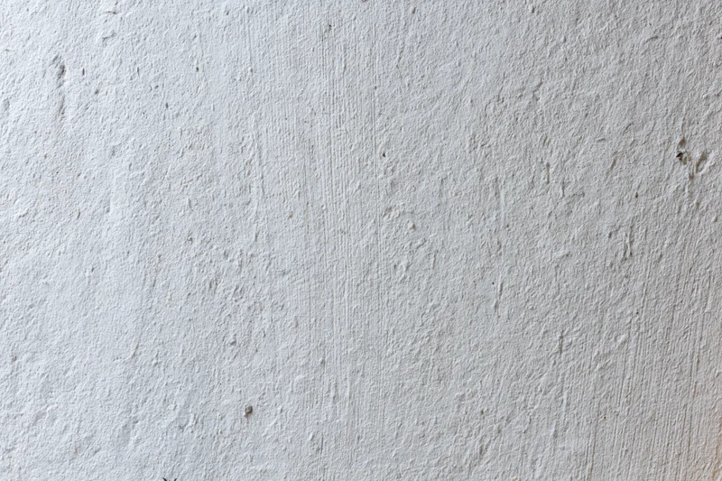 Close-up of a textured concrete wall surface showing rough gray finish with minor imperfections
