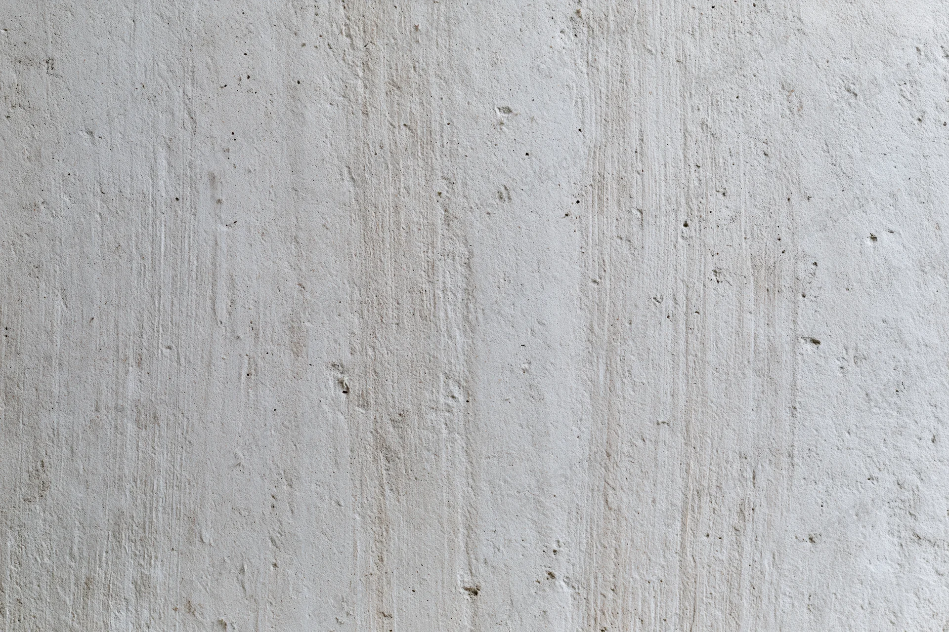 Close-up of a textured concrete wall surface with vertical streaks and minor imperfections