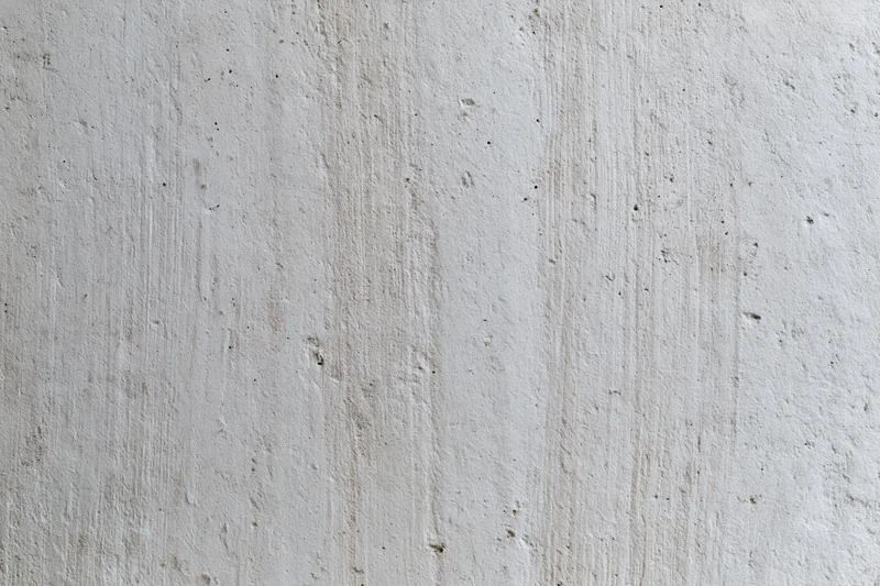 Close-up of a textured concrete wall surface with vertical streaks and minor imperfections