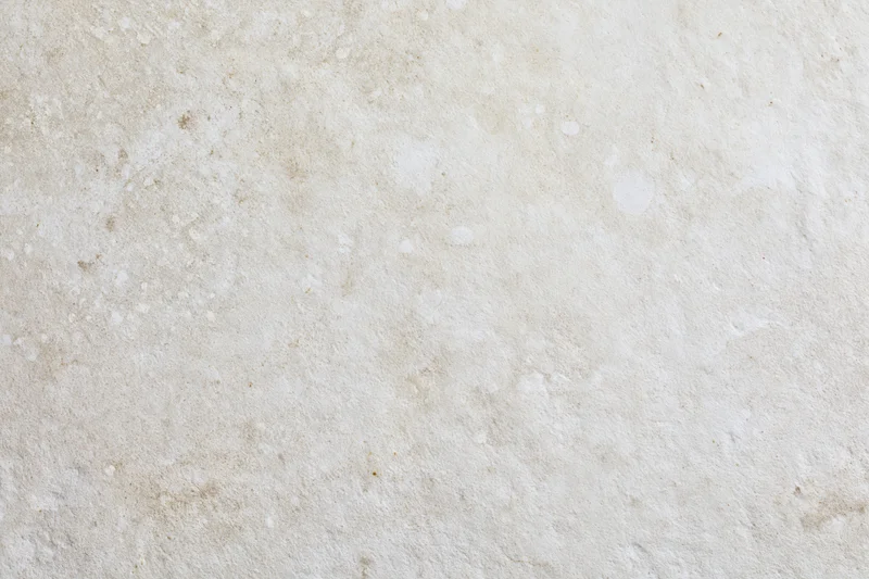 Close-up of a smooth limestone or concrete surface with natural texture and neutral beige tone