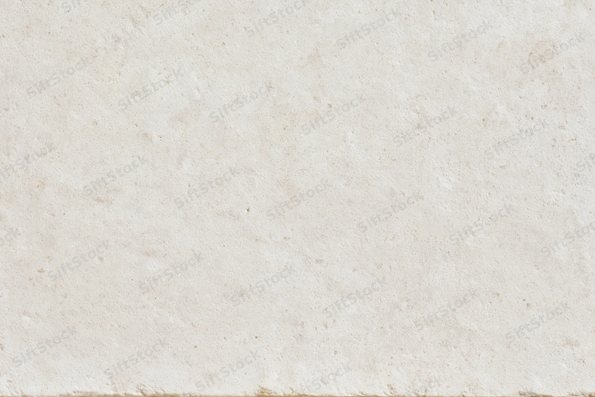Close-up of a smooth beige limestone or concrete surface with natural texture and speckles