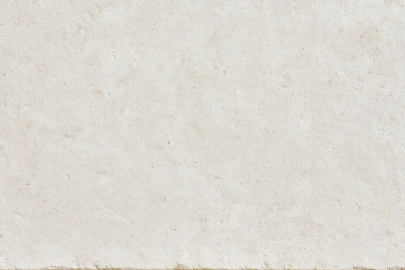 Close-up of a smooth beige limestone or concrete surface with natural texture and speckles