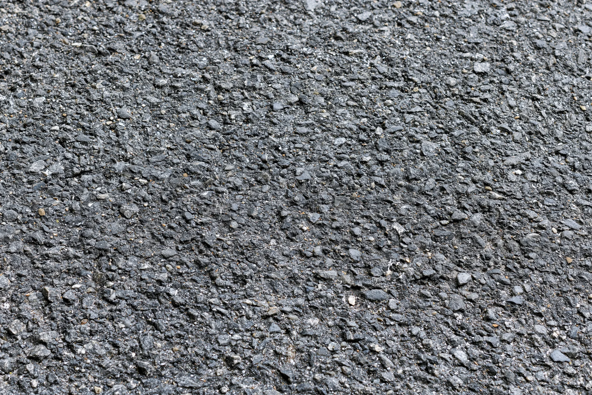 Close-up of rough asphalt road surface filling the frame