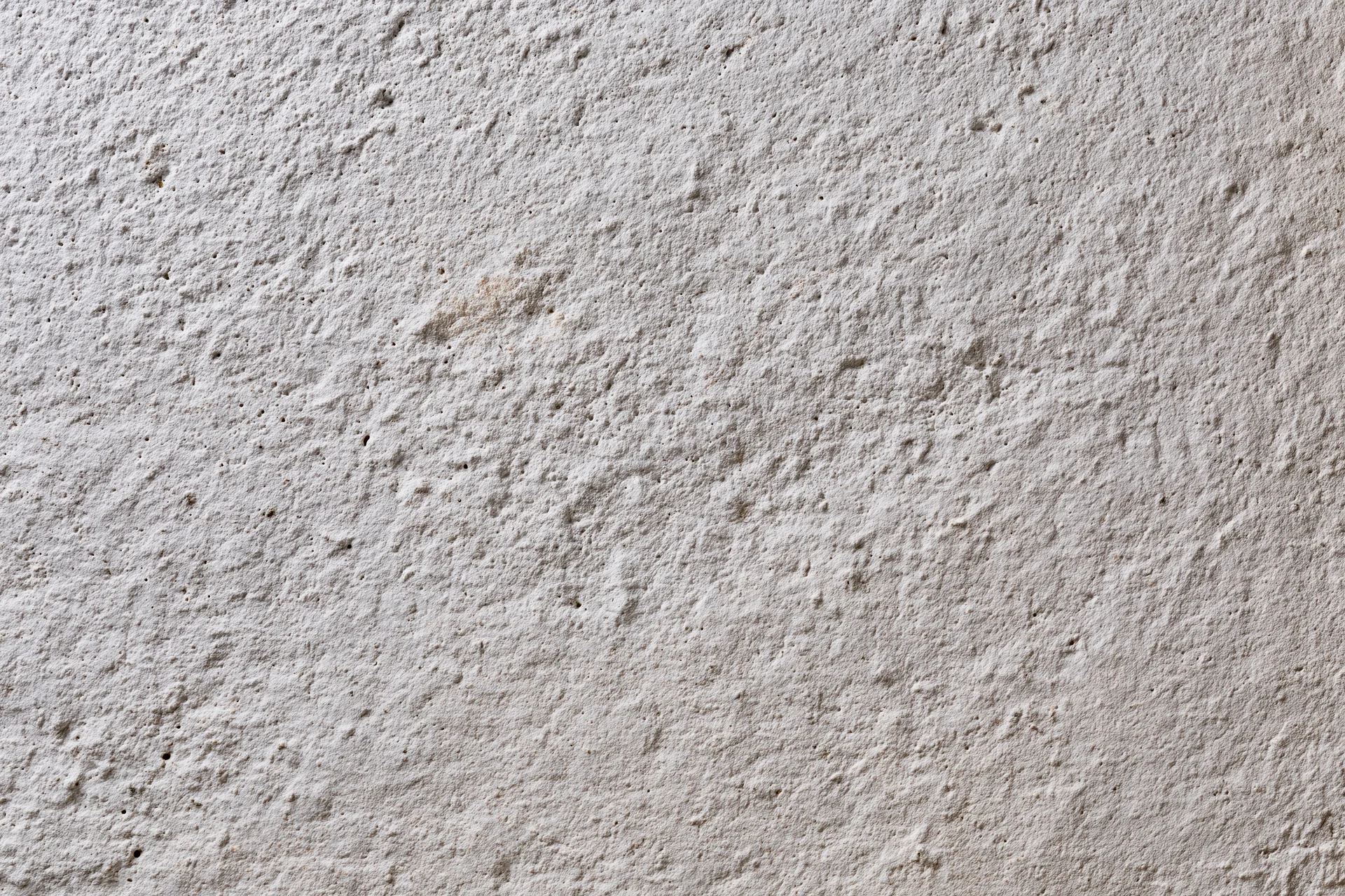 Close-up of a rough concrete wall surface with visible texture and grain