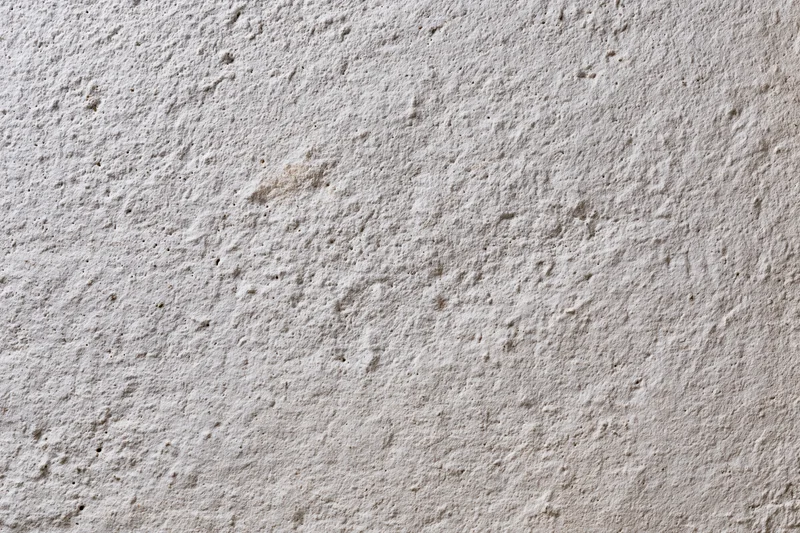 Close-up of a rough concrete wall surface with visible texture and grain