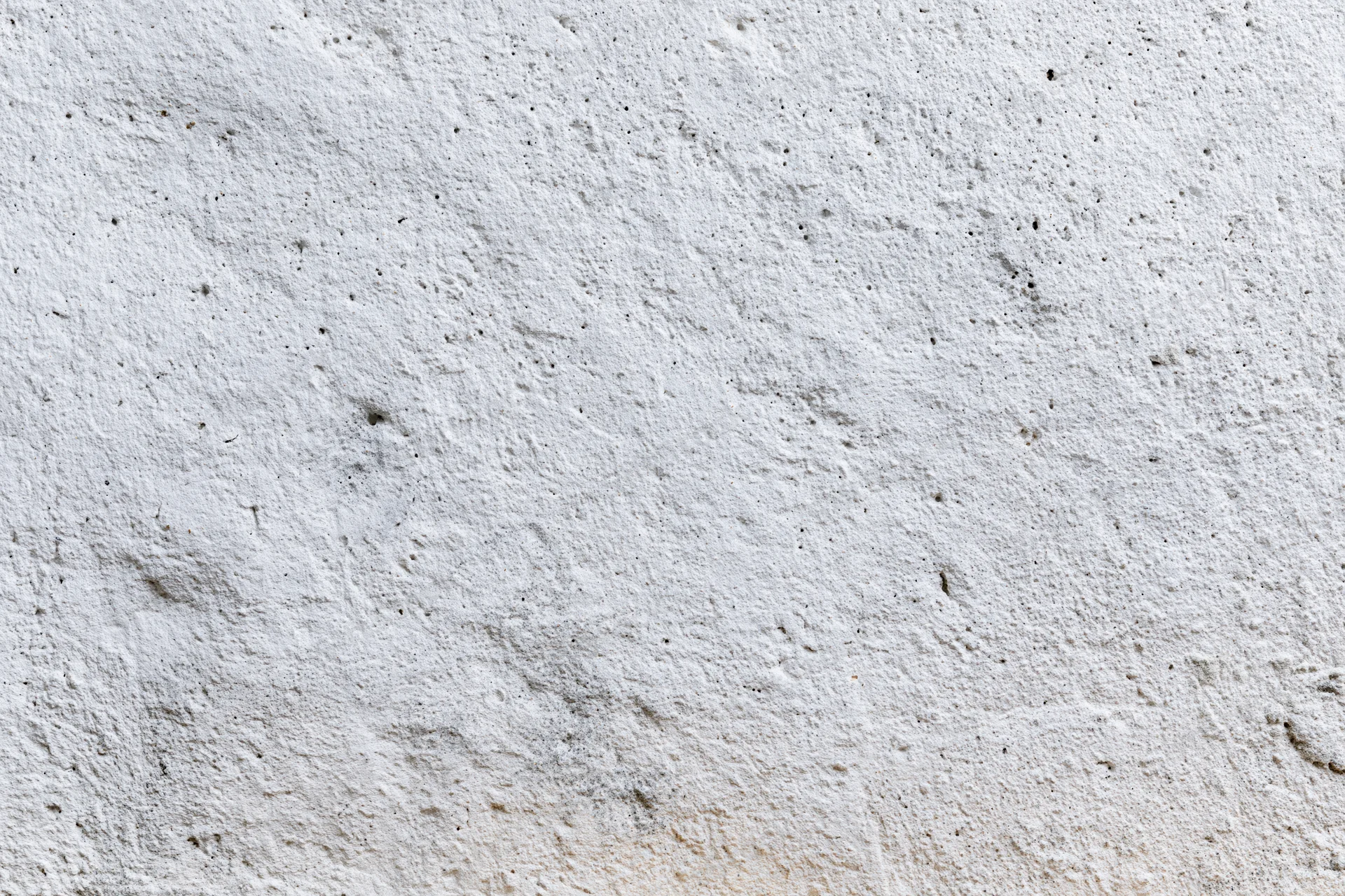 Close-up of a rough concrete wall surface with visible texture and small imperfections