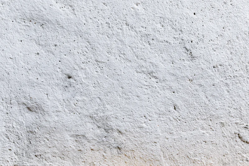 Close-up of a rough concrete wall surface with visible texture and small imperfections