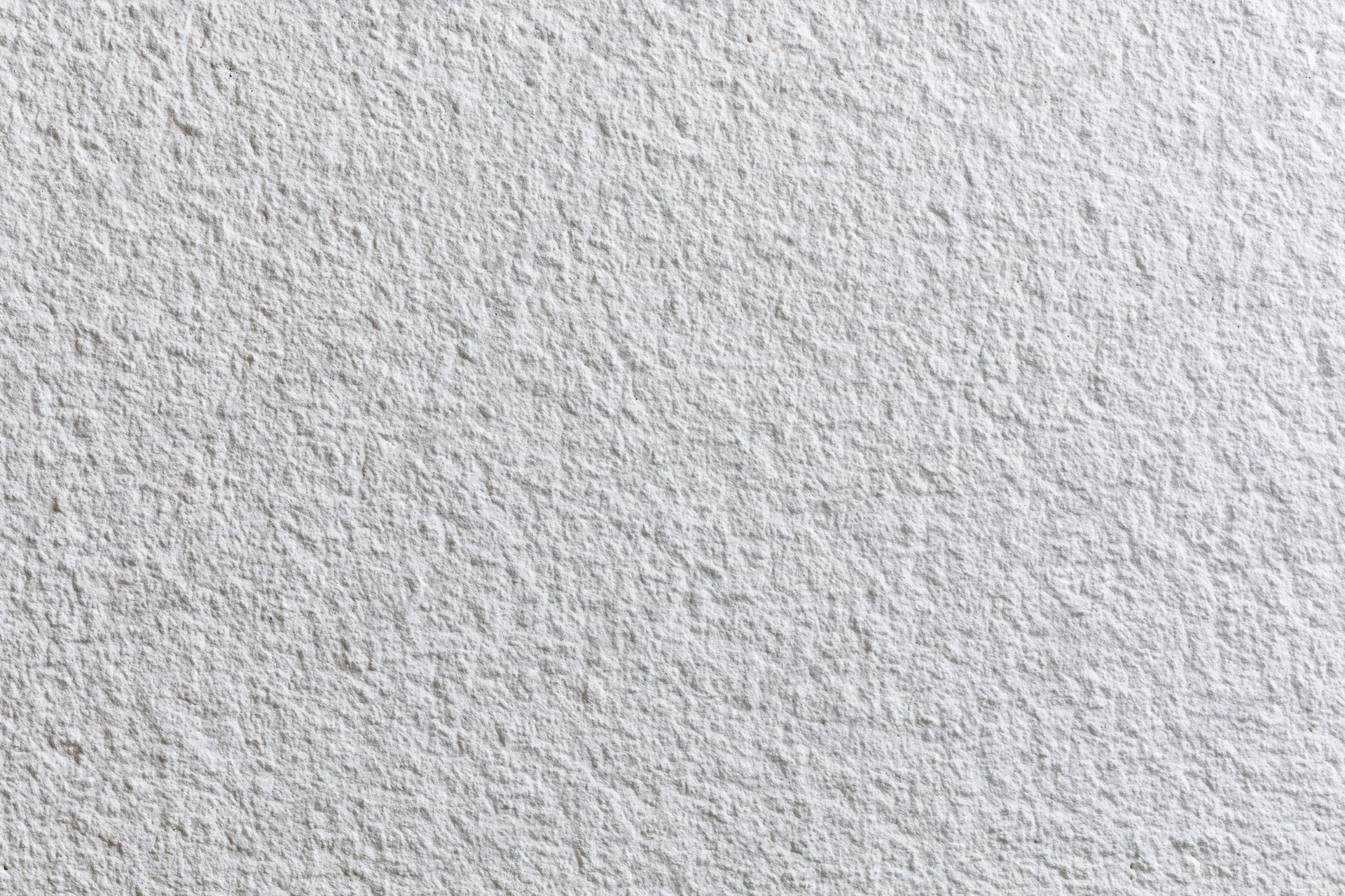 Close-up of a white stucco wall surface with textured finish