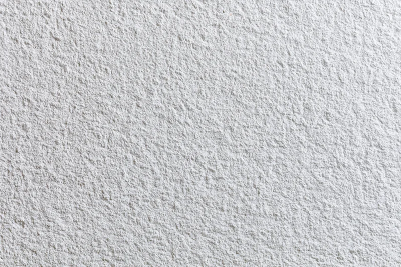 Close-up of a white stucco wall surface with textured finish