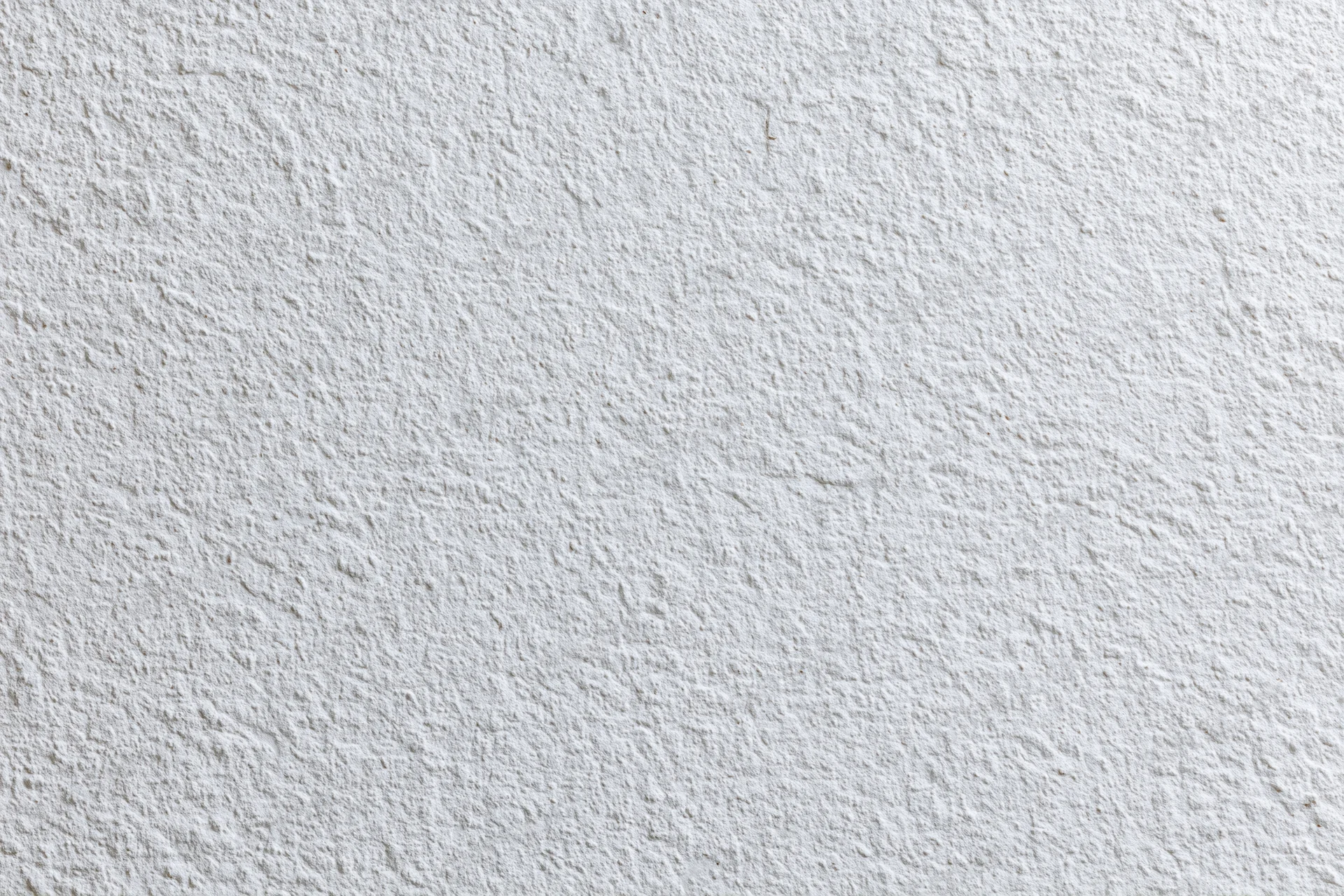 Close-up of a white stucco wall surface with rough texture