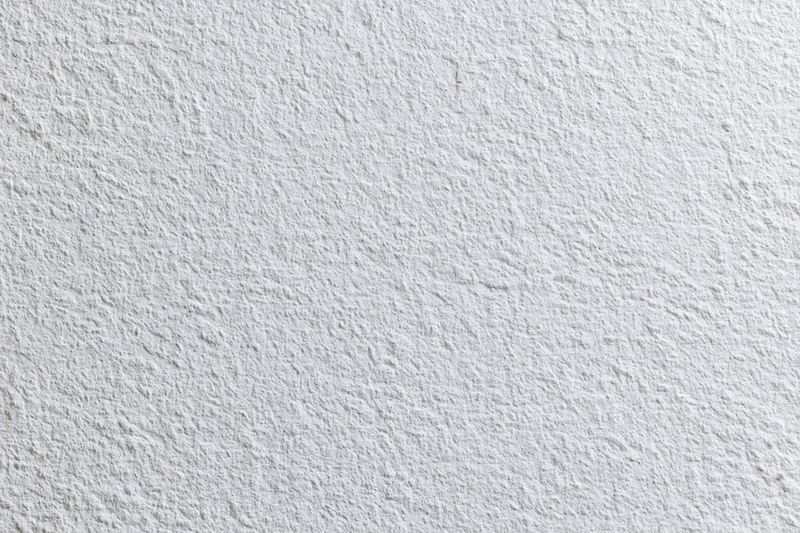 Close-up of a white stucco wall surface with rough texture