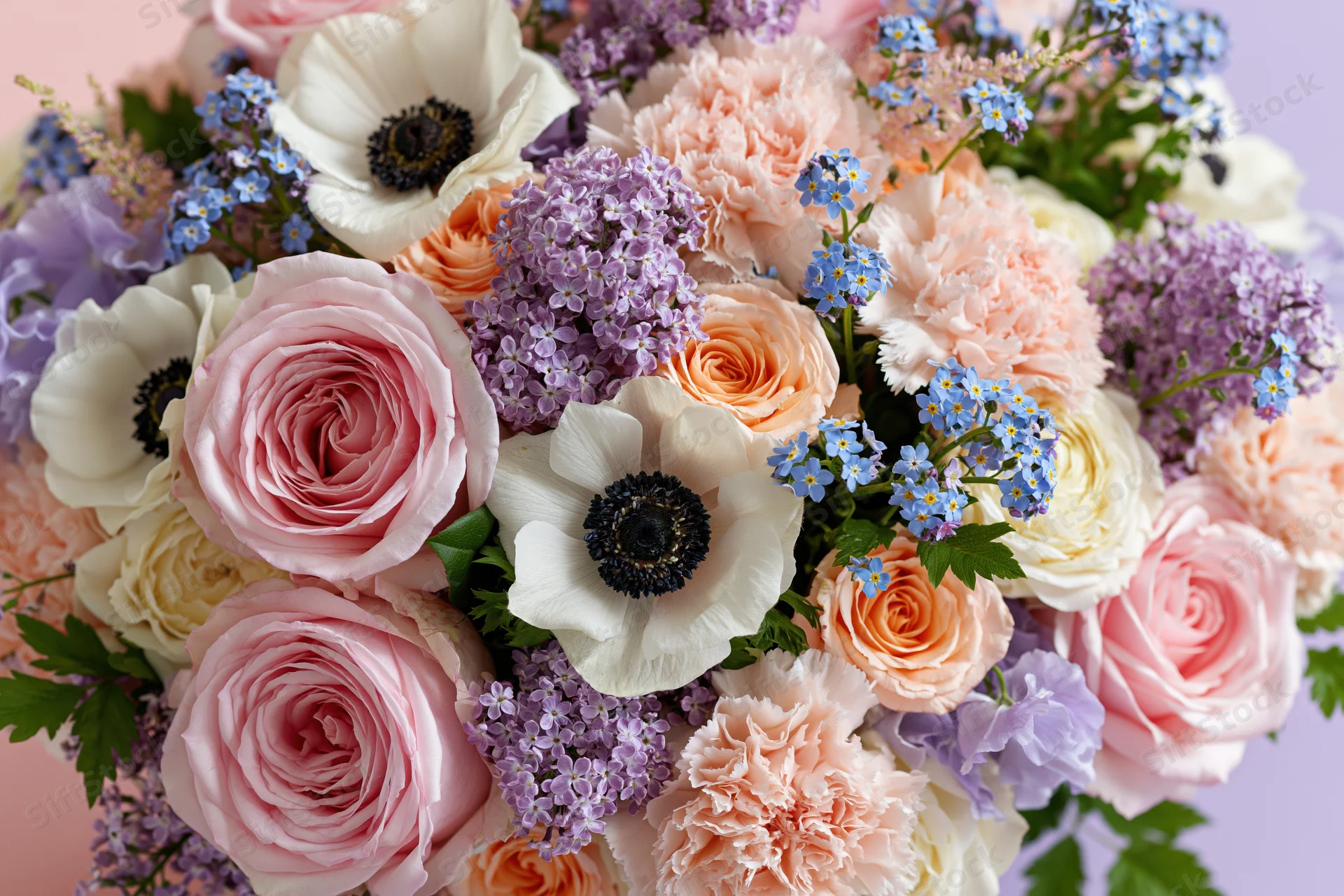 Close-up of a lush mixed flower bouquet with pink roses, white anemones, and purple lavender against a soft pastel background