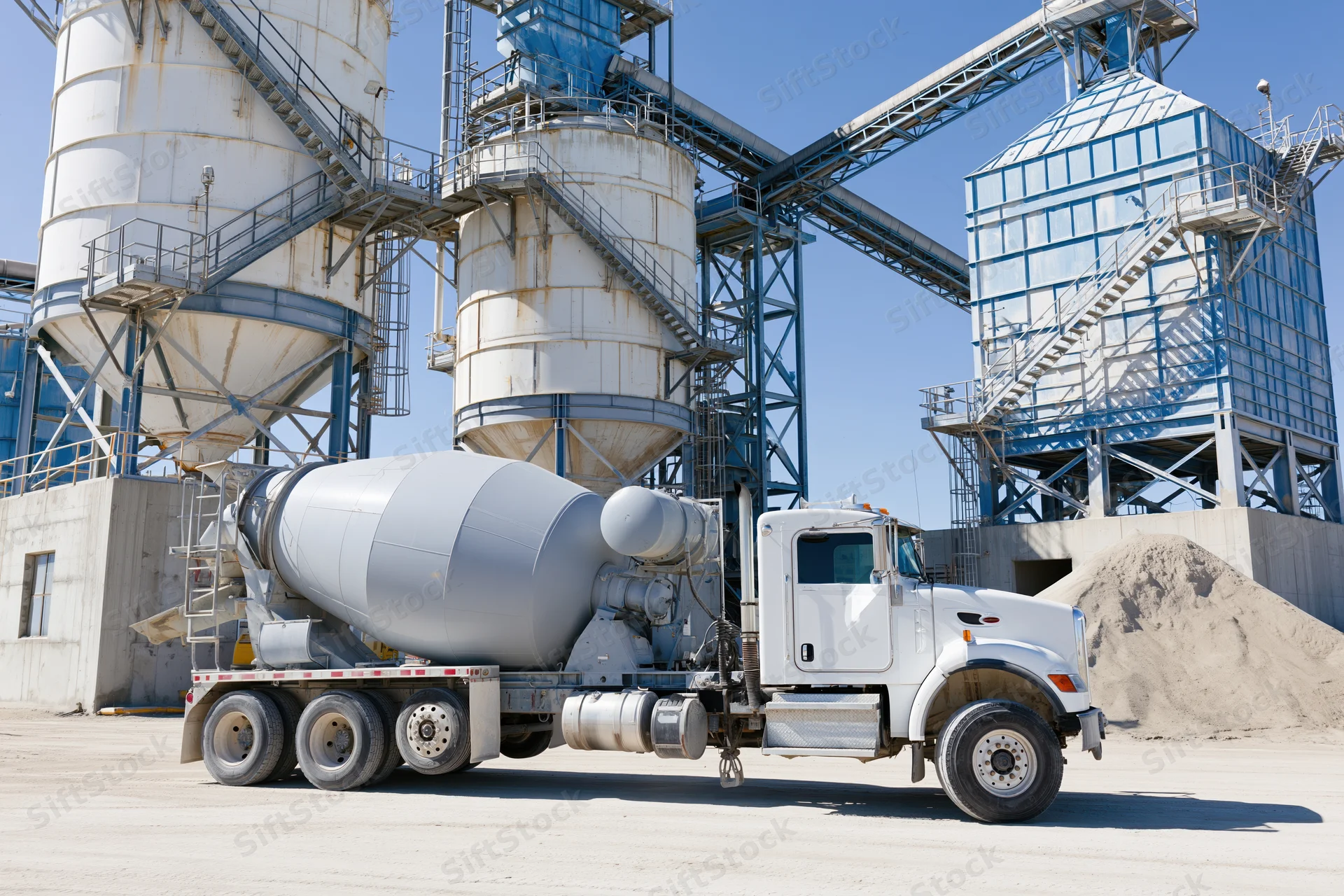 White concrete mixer truck parked at cement batching plant facility