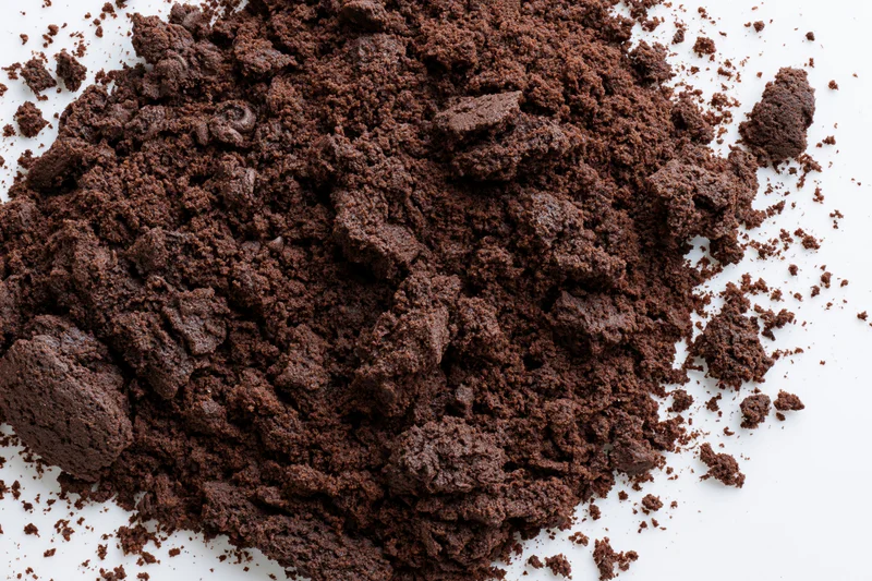 Chocolate cake crumbs scattered in a pile on a white surface